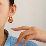 'GUID' Golden earrings with a red bead